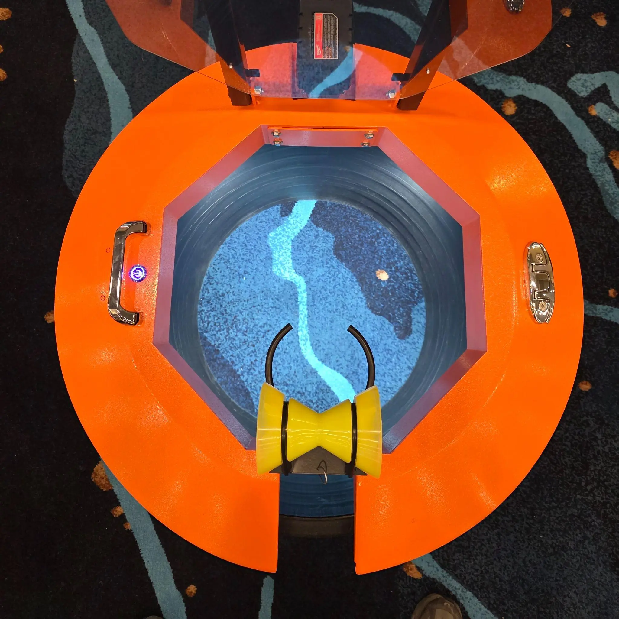 Top-down view of Light Ring covering a manhole opening with visible shield and hose guide in place.