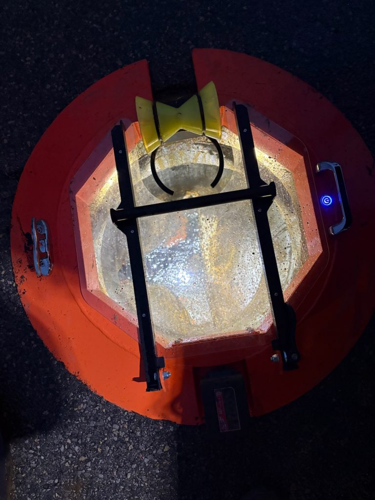 Light Ring 6,000-lumen LED system illuminating a manhole opening, providing OSHA-compliant hands-free work area visibility. 