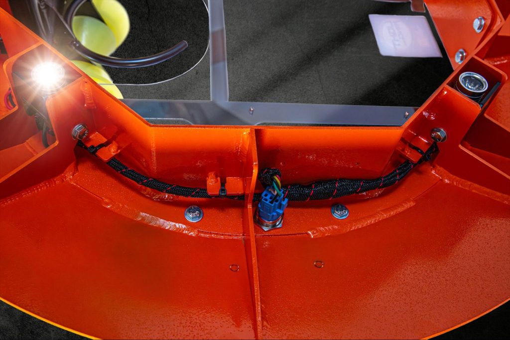 Close-up detail of the Light Ring manhole cover ring showing aluminum frame construction, sealed wiring harness with Deutsch connector, LED module, and downrigger roller.