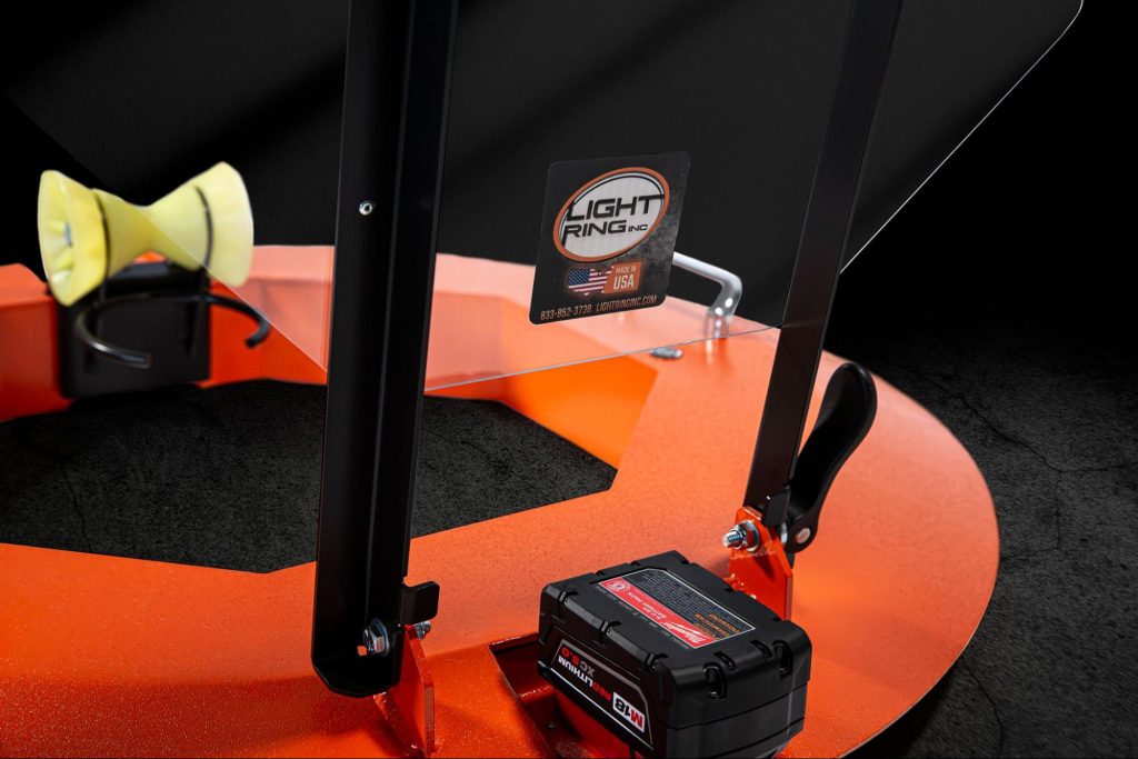 The Light Ring integrated manhole protection system showing the aluminum frame, downrigger roller, plexiglass safety cover, and battery power source.